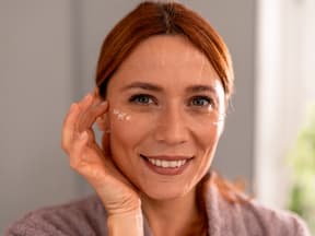 Rothaarige Frau mit Augencreme