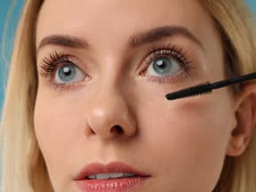 Frau tuscht Wimpern