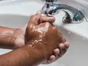 Hände werden am Waschbecken gewaschen