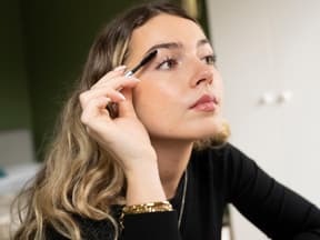 Frau tuscht sich Wimpern an