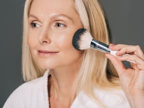 Reife Frau trägt Make-up auf