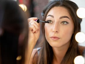 Frau tuscht Wimpern an