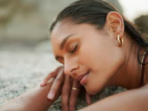 Frau liegt am Strand