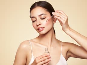 Frau im Tank-Top trägt Serum auf