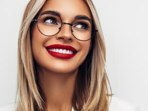 Schöne Frau mit Brille und roten Lippen