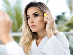 Frau tuscht die Wimpern an