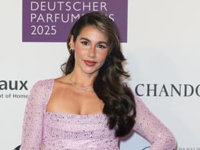 Sarah Engels im lila Glitzerkleid, lächelt leicht