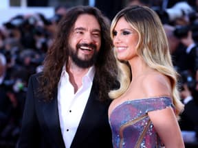 Tom Kaulitz lacht Heidi Klum an, Fotografen im Hintergrund