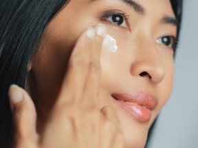 Asiatische Frau mit Augencreme