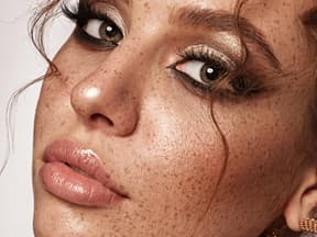 Frau mit Sommersprossen und glänzenden Lippen