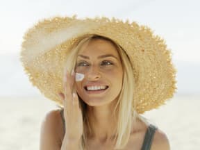 Blondine trägt Sonnenschutz auf