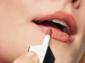 Frau trägt Lippenfarbe auf