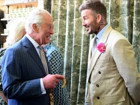 König Charles und David Beckham stehen sich gegenüber und lachen