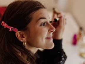 Frau tuscht sich die Wimpern