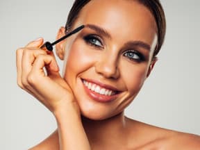 Frau schminkt Wimpern