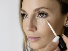 Frau trägt Concealer auf