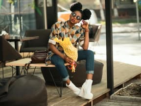 Eine junge Frau mit Jeans und buntem Shirt