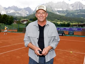 Hans Sigl vor Bergkulisse auf Tennisplatz