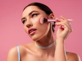 Frau trägt Blush mit Pinsel auf