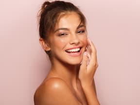 Junge Frau mit Sommersprossen strahlt