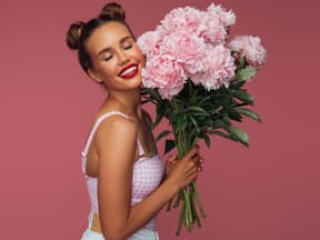 Frau mit großem Strauß Pfingstrosen