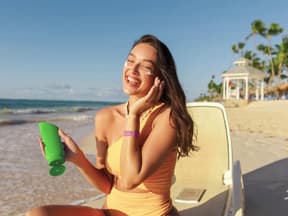 Frau cremt sich am Strand ein