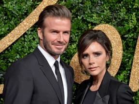 David und Victoria Beckham posieren vor grüner Wand