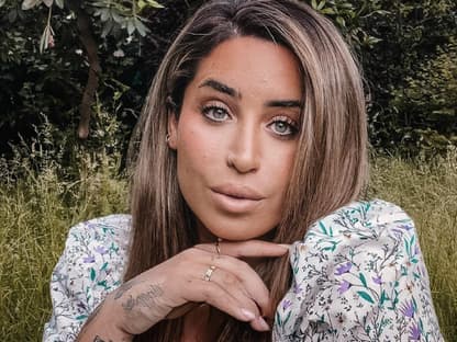 Jolina Mennen macht ein Selfie im Garten und trägt ein Blümchenkleid