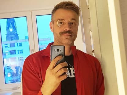Raphael Schneider macht ein Selfie vor dem Spiegel.