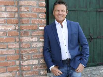 Stefan Mross moderiert "Immer wieder sonntags" und schaut lächelnd in die Kamera