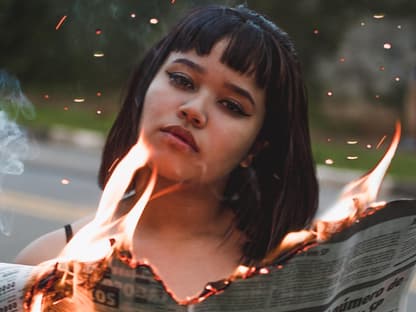 frau mit flammender Zeitung