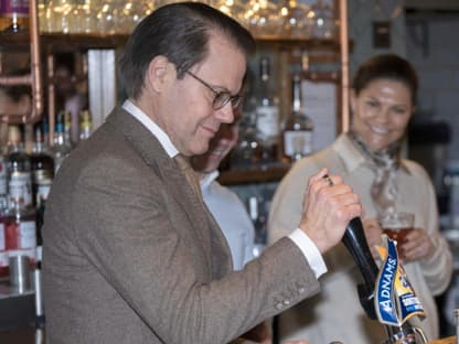 Prinz Daniel von Schweden zapft ein Bier.