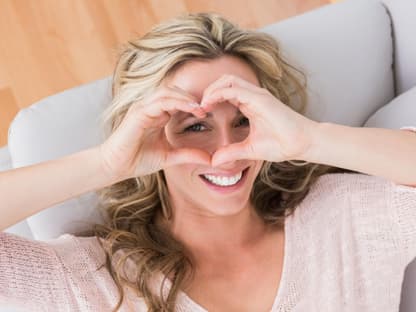 Frau Puffy Eyes Tricks Frau formt Herz über AUgen