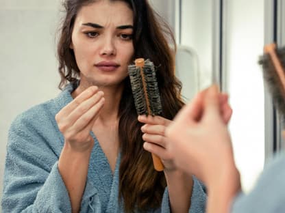 Tricks gegen Haarausfall Frau nimmt Haare aus Bürste