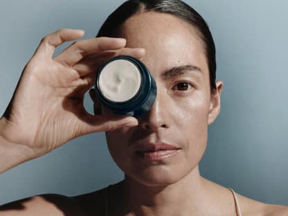 Neue Nachtcreme von La mer Frau hält Creme-Tiegel vor Auge