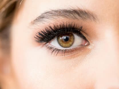 Mascara, die für Panorama-Volumen sorgt Frau mit sehr vollen und dichten Wimpern
