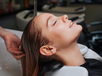 Haarmaske von Friseuren Frau im Friseurwaschbecken