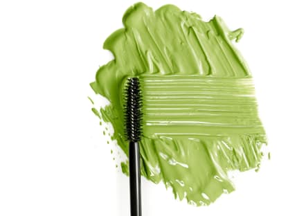 Grüne Mascara für braune und graue Augen Grüne Mascara Fleck auf weißen Hintegrund
