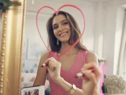 Selbstliebe Frau malt mit Lippenstift Herz an Spiegel