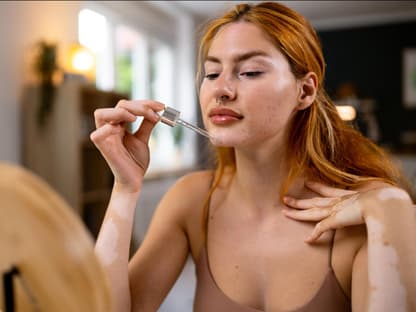 Serum gegen UNREINHEITEN IM GESICHT Frau mit Unreinheiten benutzt Serum