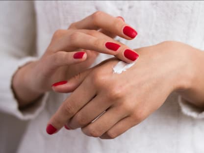 Handcreme von Hand-Model Frau creme Hände ein