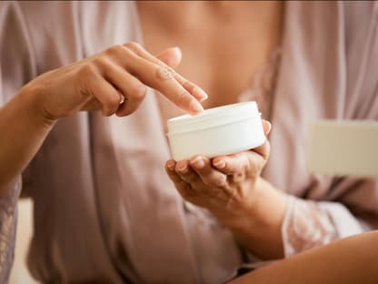 Anti-Aging-Creme mit Kollagen Frau greift in Creme-Tiegel