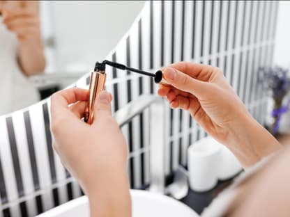 Preisgekrönte Mascara Frau hält Mascara in Hand