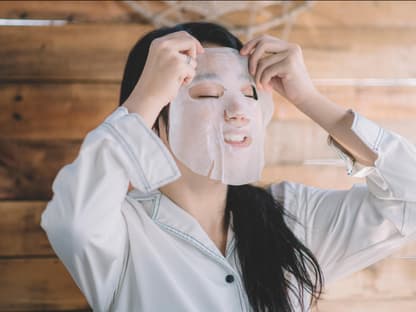 Maske von Daytox mit Vitamin C Frau legt Tuchmaske auf