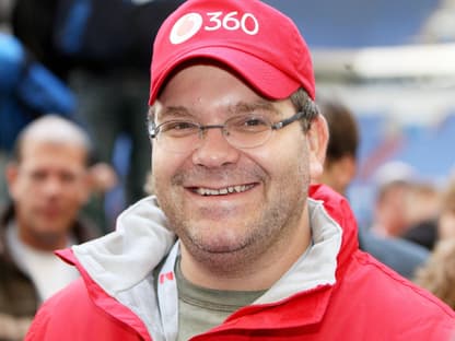 Elton lächelt mit roter Kappe