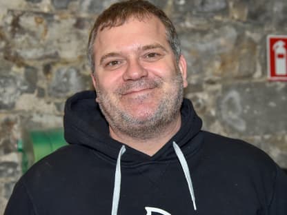 Elton ohne Brille vor Wand