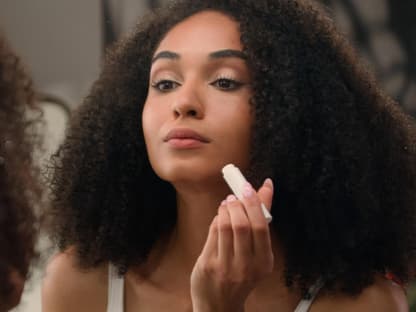 Foundation Stick Frau trägt foundation auf