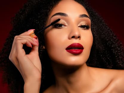 Mascara next Level Frau mit Locken tuscht Wimpern