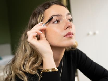 Frau tuscht sich Wimpern an