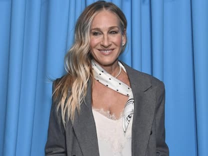 Sarah Jessica Parker strahlt vor blauen Vorhang